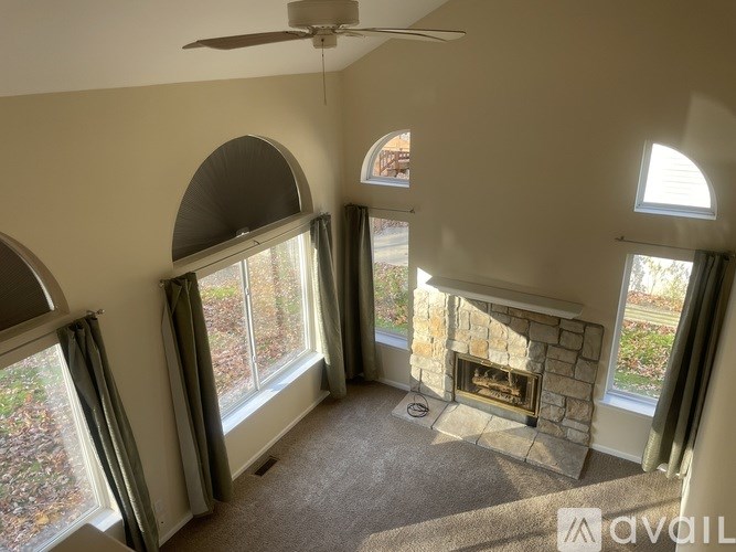 A living room with a fireplace and a ceiling fan.