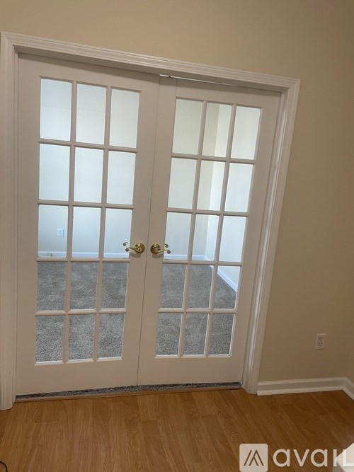 A white double door with a glass panel and a gold handle.