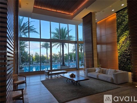 A living room with a pool outside the window.