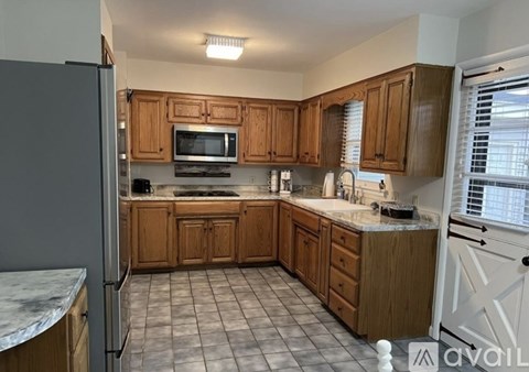 A kitchen with wooden cabinets and a marble countertop.