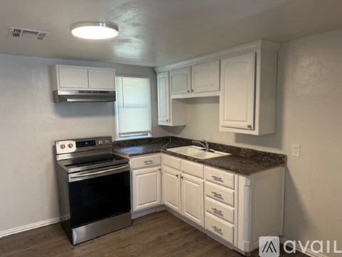 A kitchen with white cabinets and a stainless steel oven.