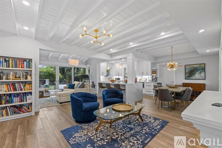 A living room with a blue rug and a glass coffee table.