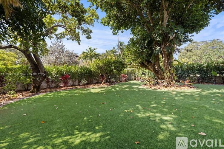 A backyard with a well-maintained lawn and trees.