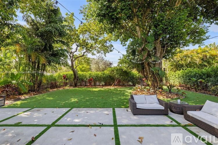 A backyard with a white lawn and a green border.