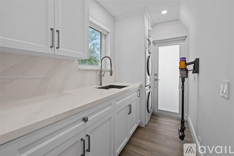 A kitchen with white cabinets and a marble countertop.