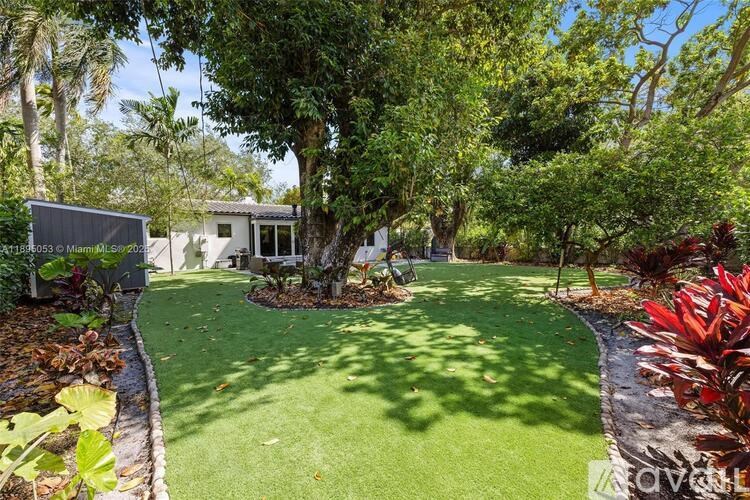 A backyard with a lawn and a house in the background.
