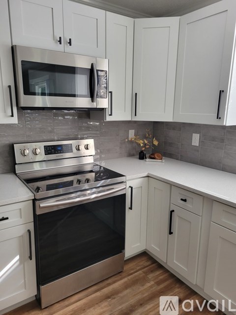 A kitchen with white cabinets and a stainless steel oven.