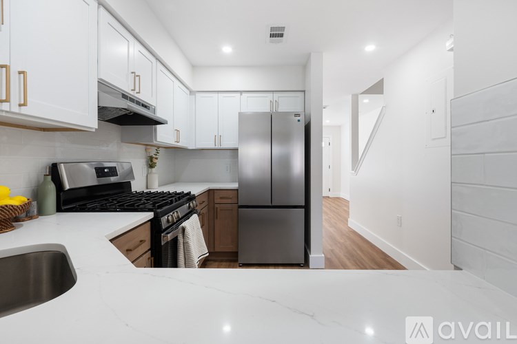 A kitchen with a refrigerator, stove, and sink.