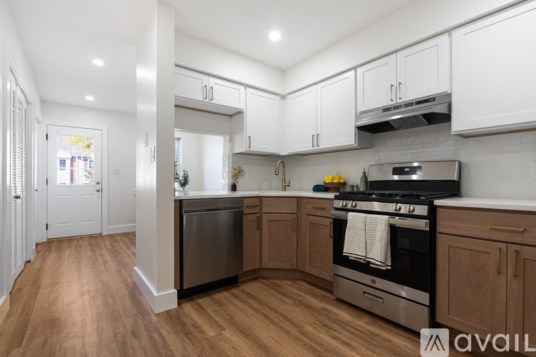A kitchen with white cabinets and a wooden floor.
