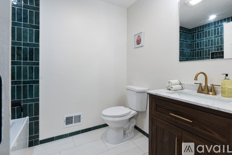 A bathroom with a toilet, sink, and a mirror.