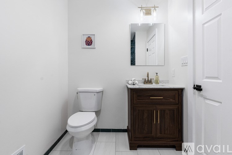 A white toilet sits next to a wooden cabinet in a bathroom.