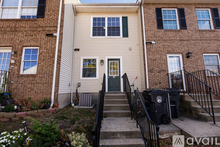 A two-story building with a beige siding and a black door.
