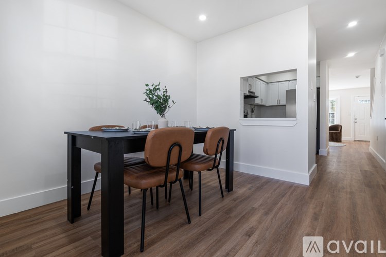 A modern dining room with a black table and chairs.