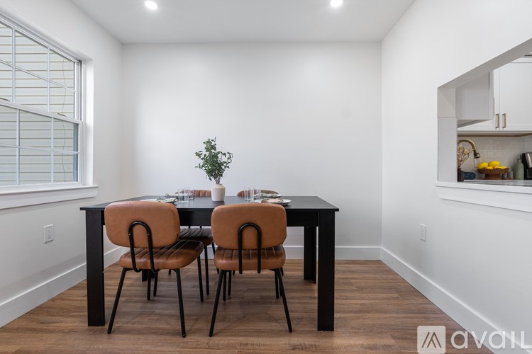 A dining room with a black table and chairs.