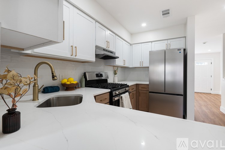 A kitchen with white cabinets and a marble countertop.