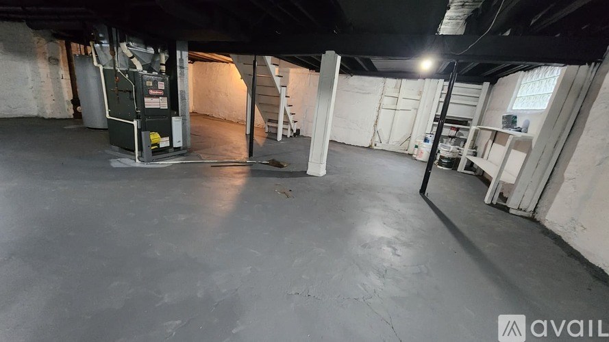 A large, empty industrial space with a concrete floor and white walls.