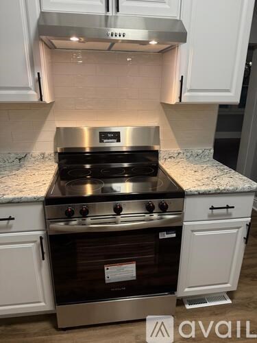 A kitchen with a stove top oven and a range hood.