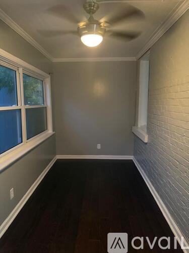 A room with a ceiling fan and a window.