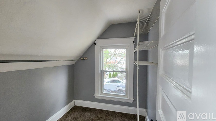 A room with a window and a car parked outside.