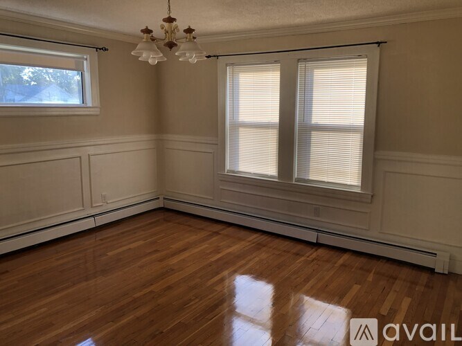 A room with wooden floors and a chandelier.