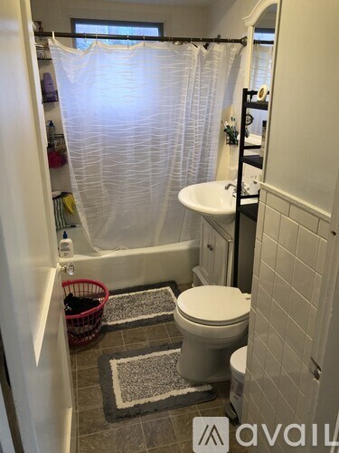 A bathroom with a toilet, sink, and shower curtain.