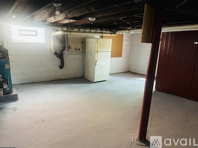 A room with a white door and a window on the left side.