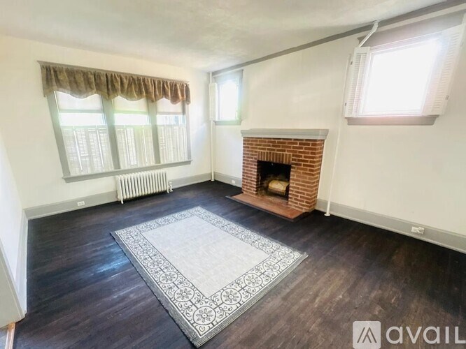 A living room with a fireplace and a rug on the floor.