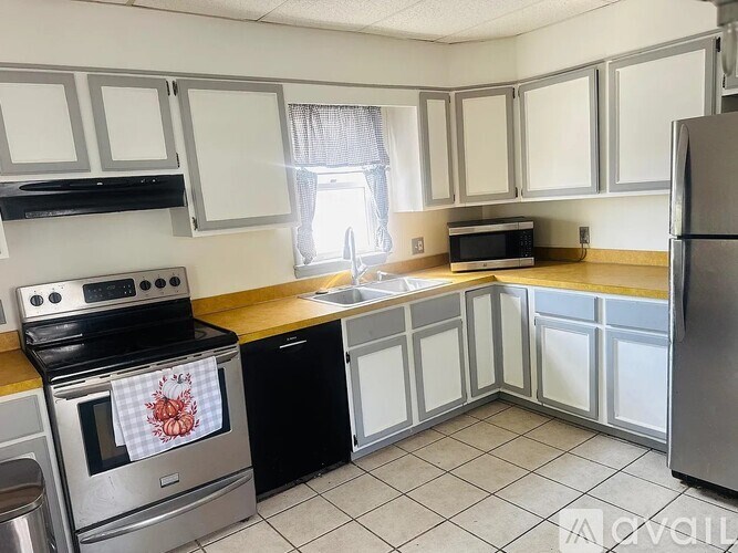 A kitchen with a stove, oven, dishwasher, microwave, and refrigerator.