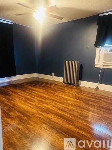 A room with a wooden floor and a ceiling fan.