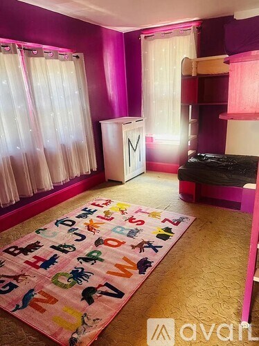 A room with a pink carpet and a white cabinet.