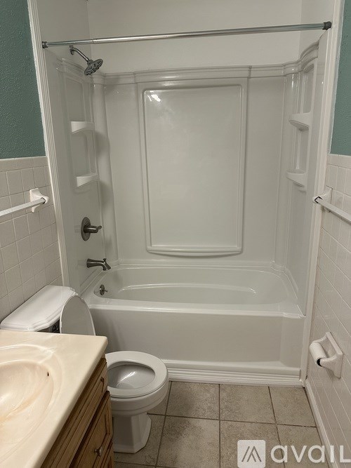 A white bathtub is in a bathroom with green walls.
