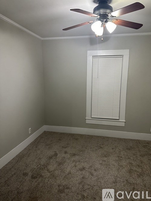 A room with a ceiling fan and a window with blinds.