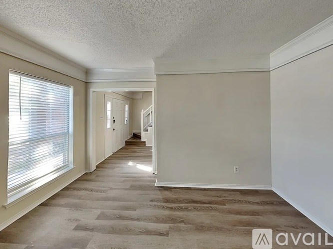 A long hallway with a carpeted floor and white walls.