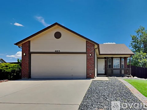 A house with a garage and a driveway in front.