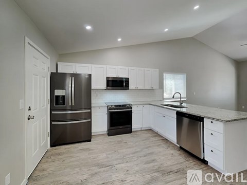 A kitchen with white cabinets and stainless steel appliances.