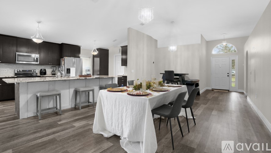 A modern kitchen with a dining table set for two.