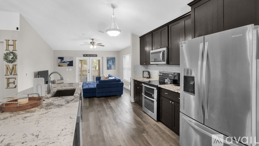 A modern kitchen with dark wood cabinets and stainless steel appliances.