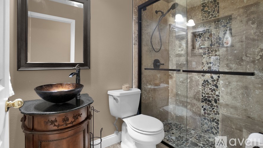 A bathroom with a toilet, sink, and shower.