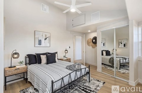 A bedroom with a large bed and a mirrored closet door.