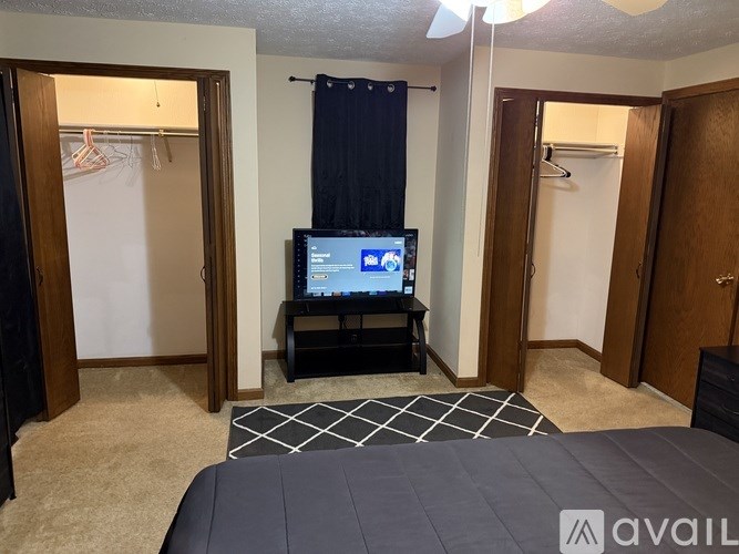 A bedroom with a bed, a TV, and a wardrobe.