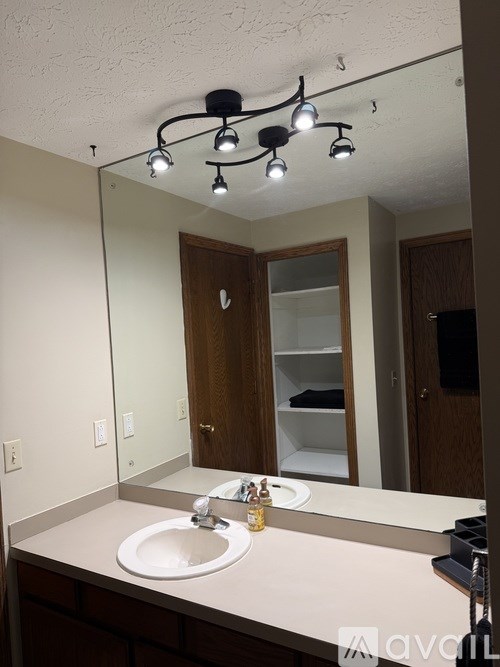 A bathroom with a sink, mirror, and lights.