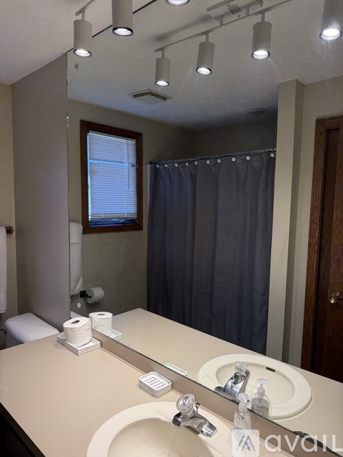 A bathroom with a sink, mirror, and toiletries.