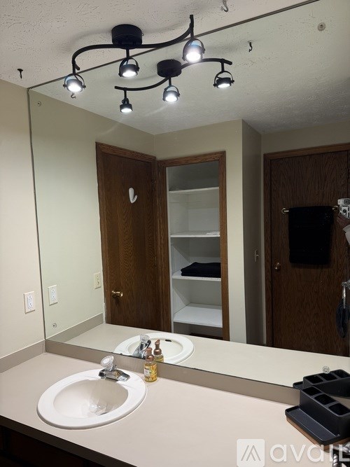 A bathroom with a sink, mirror, and lights.