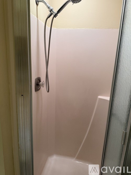 A shower with a hose attached to the wall.