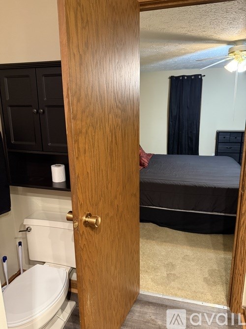 A bedroom with a bed, a toilet, and a bathtub.