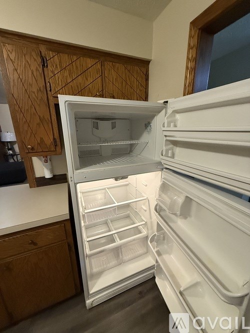 A white refrigerator with its door open in a kitchen.
