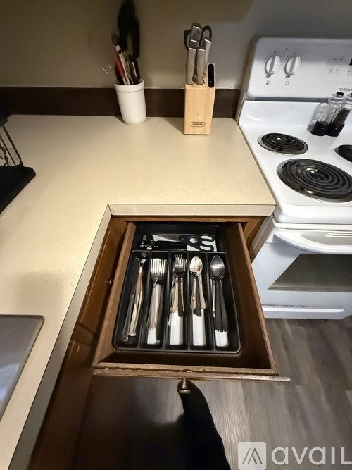A set of utensils is stored in a drawer in a kitchen.