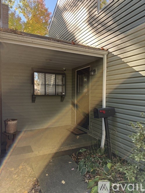 A grey house with a mailbox and a window.