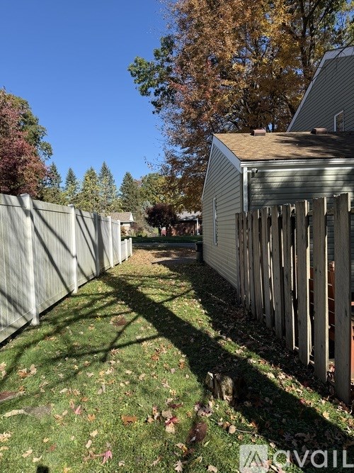 A backyard with a fence and a house in the background.