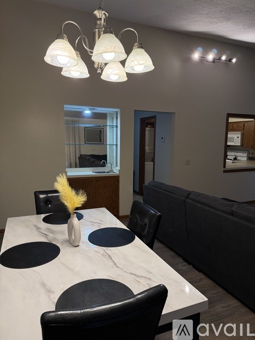 A dining room with a marble table and chairs.